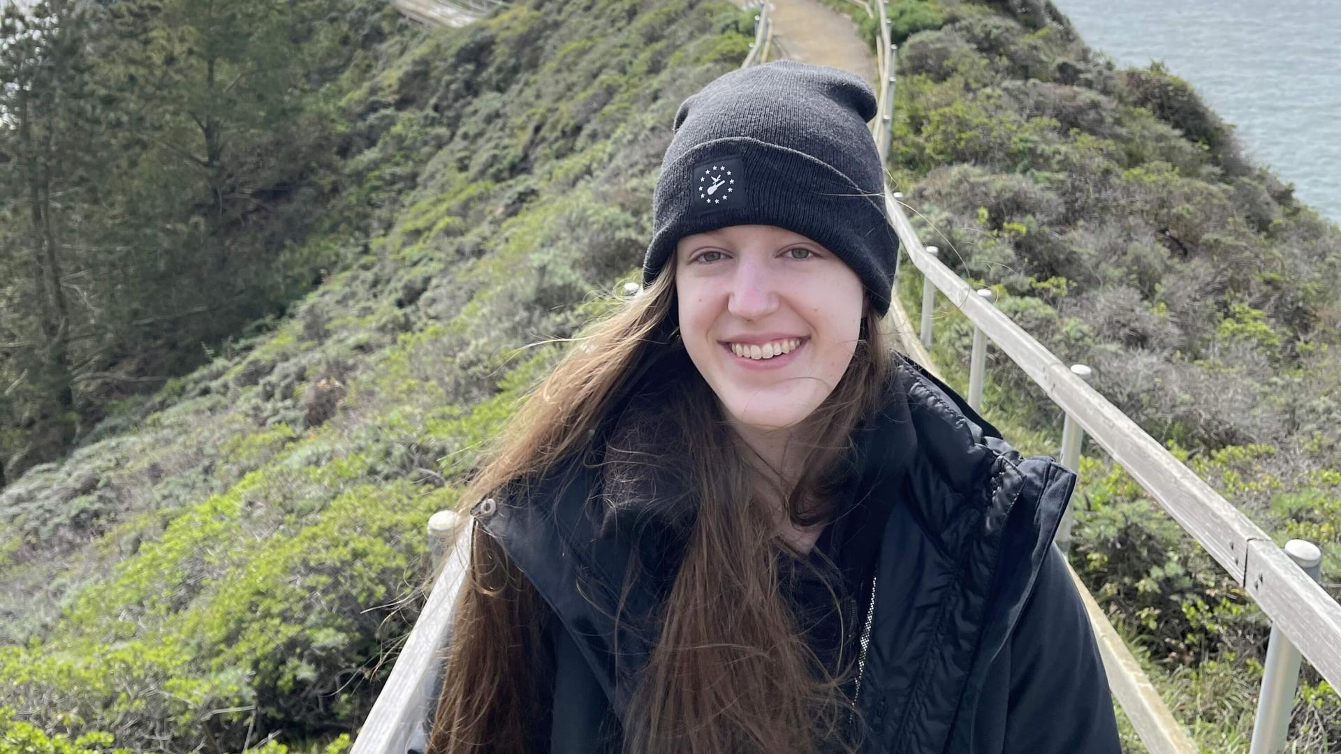 Anna smiling on a bridge on top of a mountain.